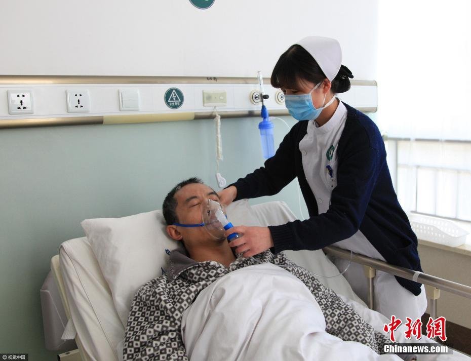 图为在石岛人民医院,护士给张乐带氧气罩.