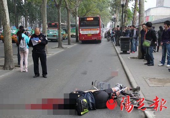 车祸现场,一名男子呈骑车姿势倒地,前面就是肇事公交车