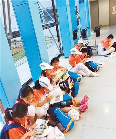 日本机场等待入关时 西安小学生席地读书获赞