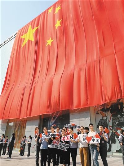 东大街群光广场响起悠扬的歌声,400余人在一面1176平方米的巨幅国旗下