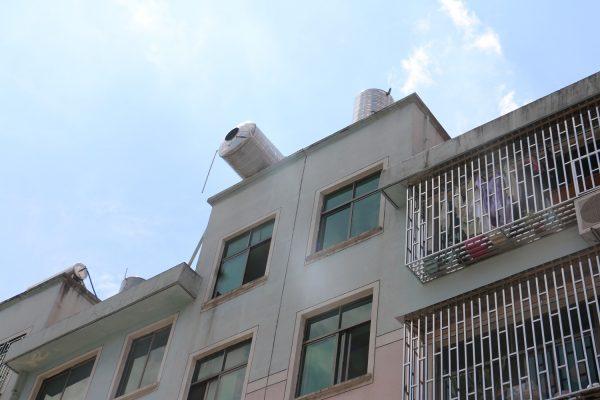 楼顶水塔突然倾斜 正在干活的男子手被夹住了