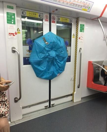 女汉子“勇”闯地铁 眼看赶不上就用雨伞撬车门