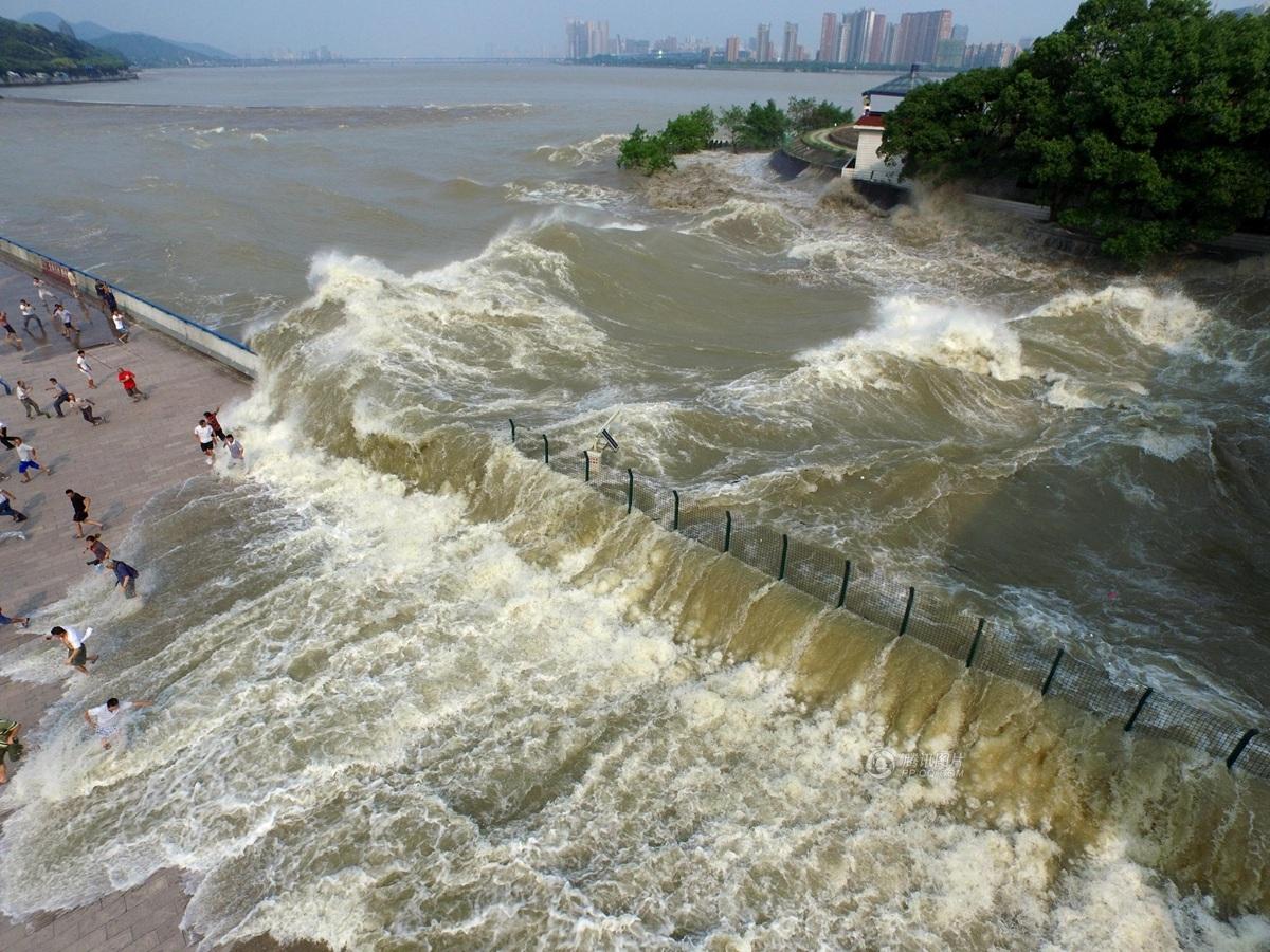 杭州九溪观潮点,潮水翻过堤坝涌向之江路,打翻不少观潮人.