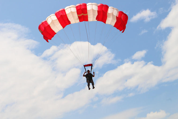 蓝天白云间,特战飞行员操作翼伞快速飞行.李仙摄