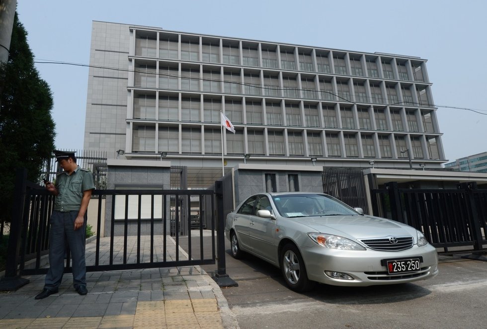 一辆悬挂外交牌照的车辆驶出日本大使馆.