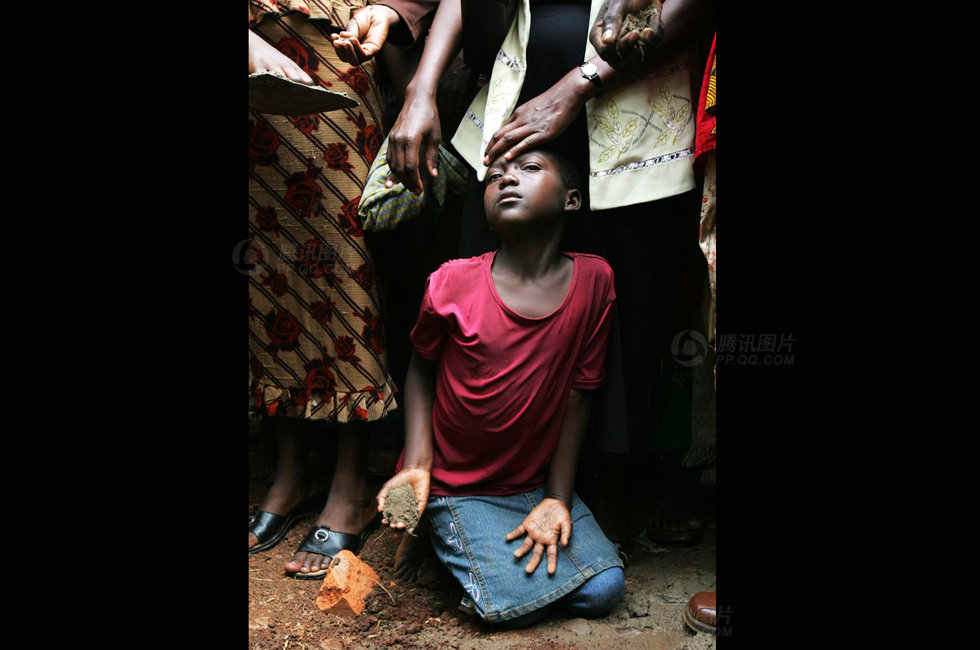 的ruth nakabonge在向他父亲的坟墓洒泥土,他的父亲因感染艾滋病去世