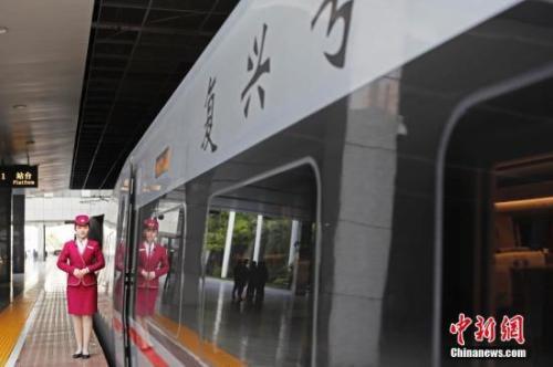 资料图：4月10日，列车员在“复兴号”列车旁迎接旅客的到来。 中新社记者 殷立勤 摄