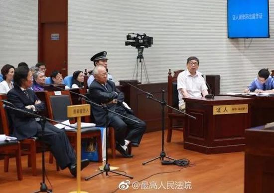 13日,顾雏军在法庭上聆听证人发言