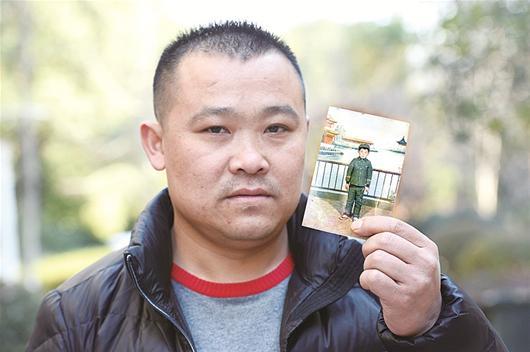 图为:李道明拿着小时候的照片 记者王永胜摄