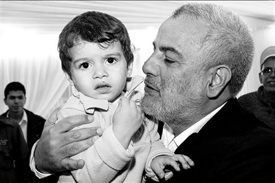 27日,阿卜杜拉·本·基兰和儿子在一起.图/人民图片