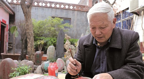 李秦生在奇石上写字