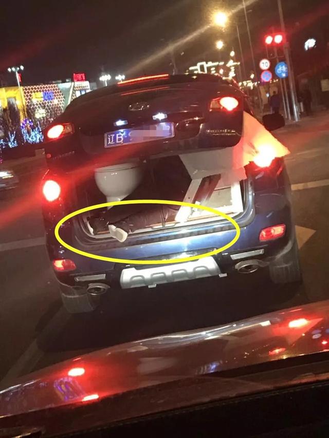 SUV等红灯时后备箱露出人腿 一只脚已悬在车外
