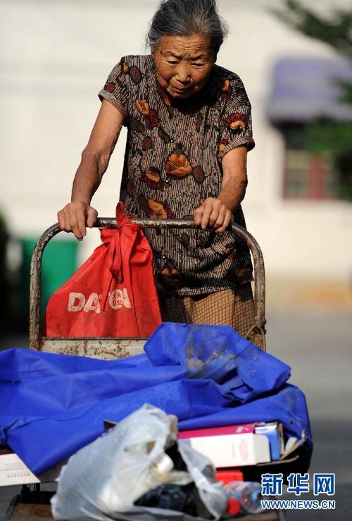 傍晚,李佳鸾老人把收来的废品推回家(7月9日摄).新华社记者 刘军喜