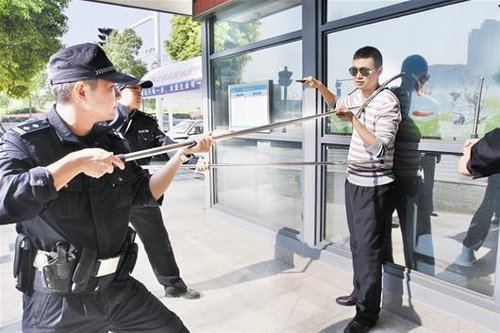 男子持刀抢劫 警察用钢叉对其"锁喉封腰"(图)