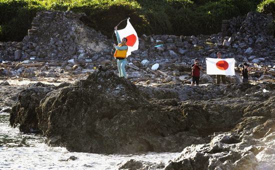 日本右翼分子昨日非法登上钓鱼岛举起日本国旗,上演一出闹剧
