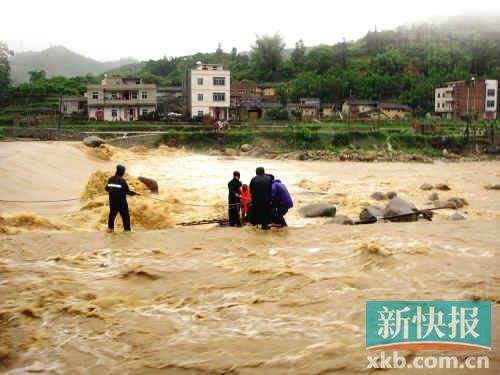 信宜市钱排镇钱排河,救援人员正在营救3名被洪水围困群众.