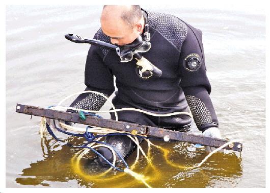 潜水队员成功在水下打捞起残骸