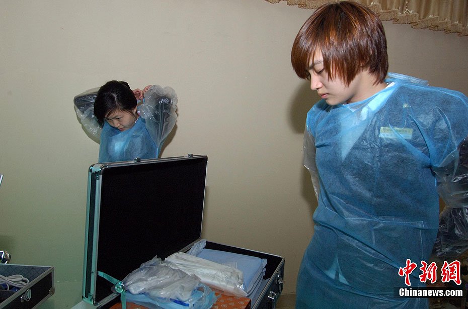 图为穿上一次性入殓服,戴上口罩和硅胶手套.吕明 摄