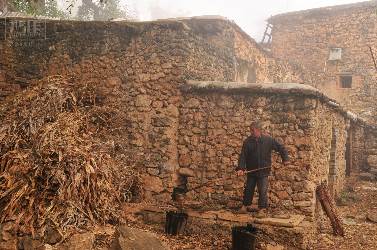 一位村民从化石建的厕所里挑大粪去浇菜.