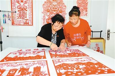 刘惠霞和徒弟窦淑花对作品进行修剪 记者 黄亚平 摄