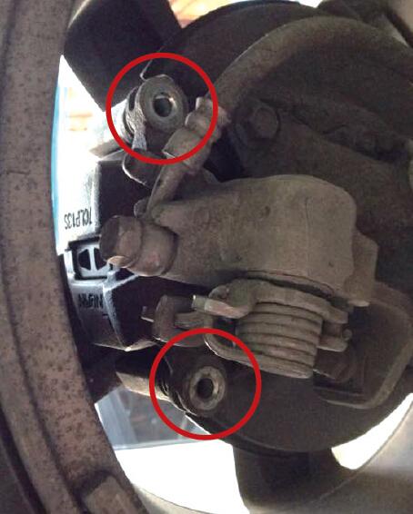 张女士发现车子有异响后送去检查，原来是左后轮刹车分泵上缺了2枚螺丝（红圈处）。张女士供图